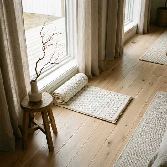 Quiet Luxury wellness scene featuring a cream-colored acupressure mat in a sunlit room.